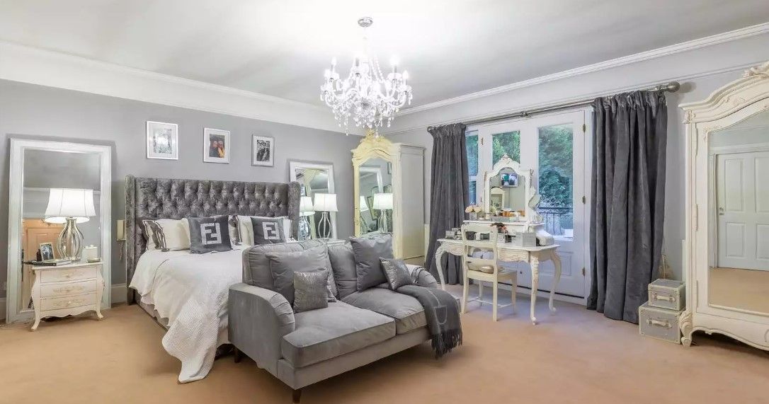 The master bedroom has a grey covered bed with en suite bathroom and bifold doors leading to a balcony