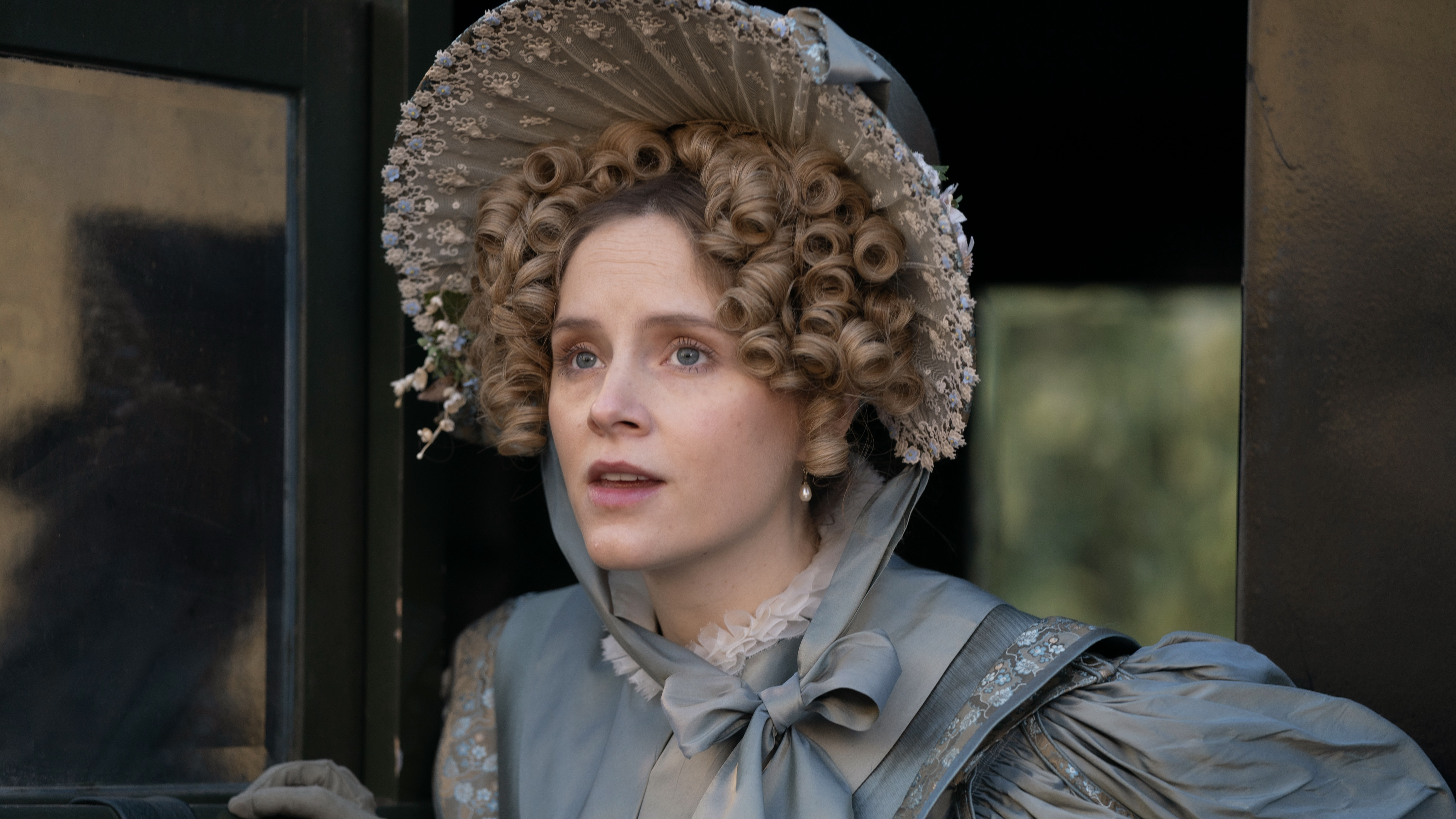 Sophie Rundle as Ann Walker in a blue dress and lacy bonnet in Gentleman Jack. Gentleman Jack in a