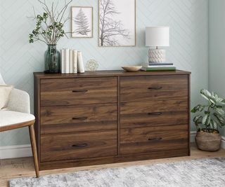 Walmart dresser with trinkets on top against a duck egg blue bedroom wall.