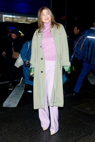 Ellen Pompeo in pink lipstick and a green trench plus pink pants and shirt