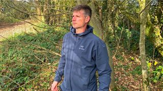Why is Arc'teryx so expensive: Man wearing Arc'teryx Gamma Lightweight Hoody in the woods