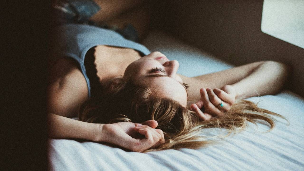 A woman lying on her back with her arms above her head