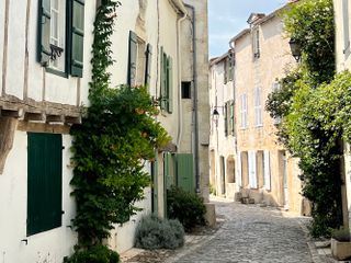 Family cycling holiday on Île de Ré allows you to take in street scenes like this one with old houses either side of a cobbled road