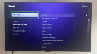 The Roku home screen with the Settings option selected (and highlighted in a green box) on the left side of the screen, the first step for Roku screen mirroring.