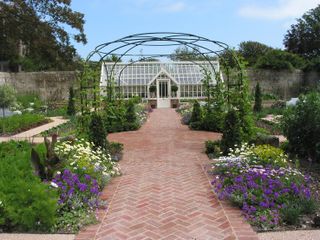 traditional handmade pavers used for a path leading to a large greenhouse