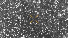 A blurry picture of stars with arrows pointing to where a comet is