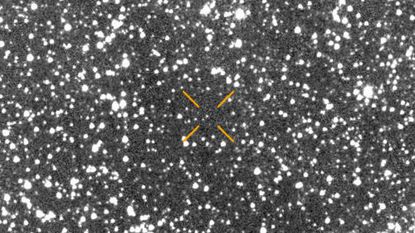 A blurry picture of stars with arrows pointing to where a comet is