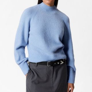 Flat lay image of a woman wearing blue jumper 