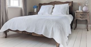 luxury bed with white oversized bedding to show how to make your bedroom feel like a hotel