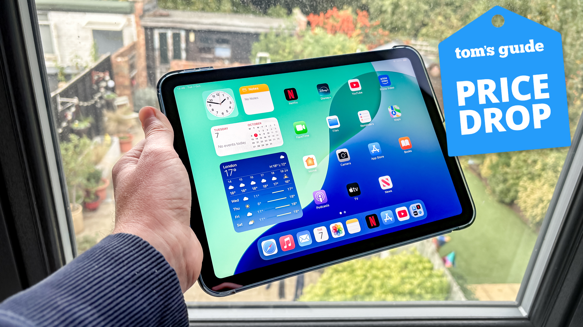 iPad 11 held in hand with Tom&#039;s Guide Price Drop badge