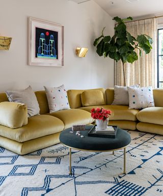 modern living room with white and blue rug and a large contemporary yellow velvet couch