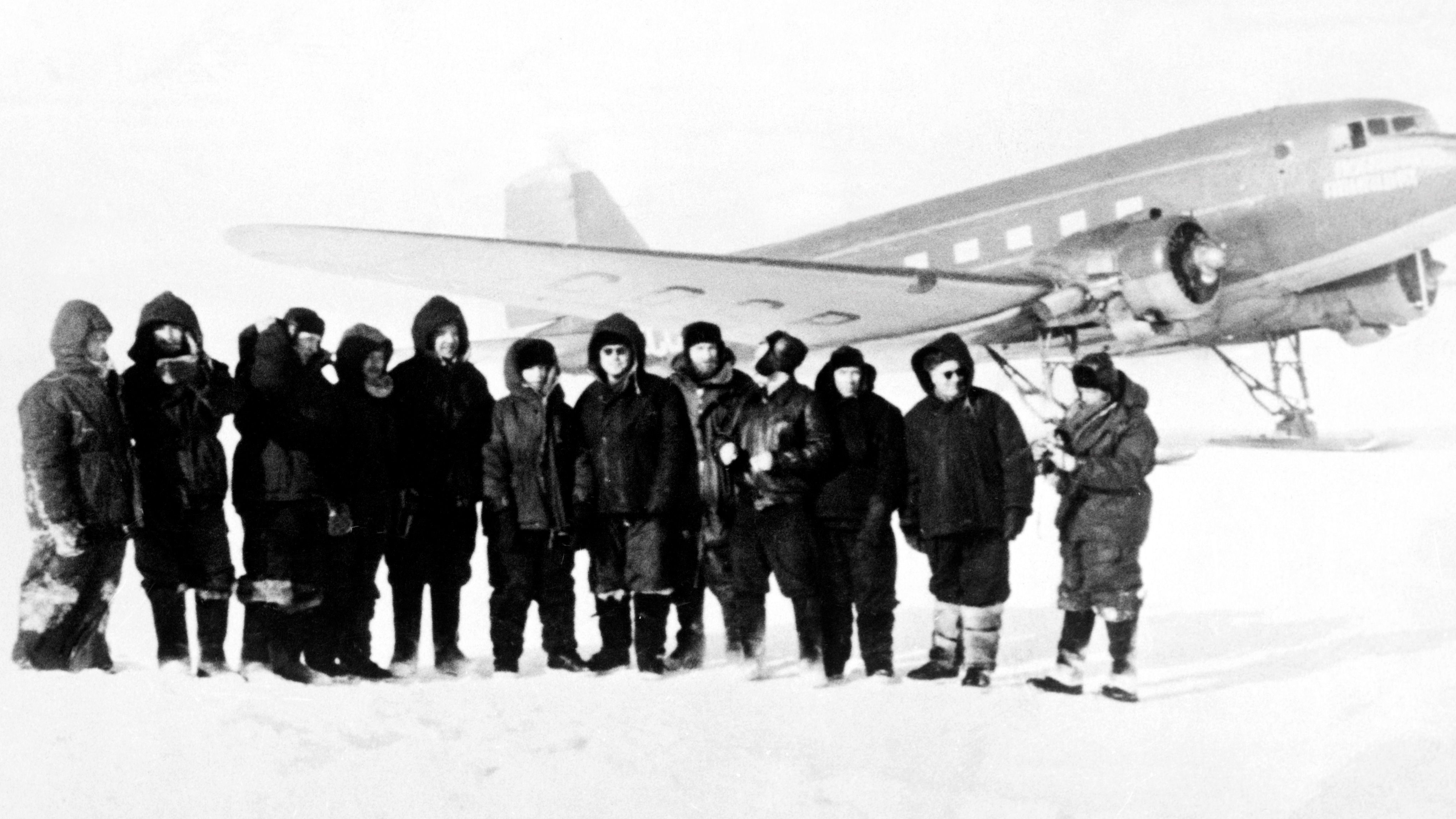 Men standing by a plane in Antarctica in 1957