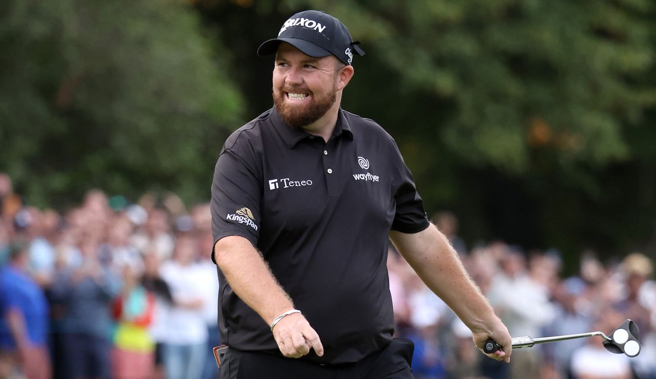 Lowry smiles whilst holding his putter