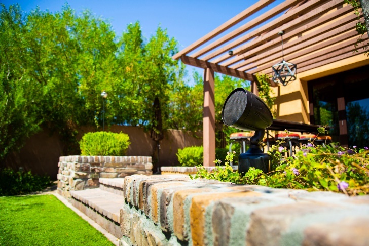 SoundTube speakers outside a facility in a pretty landscape on a sunny day.