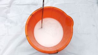 Top down shot of orange bucket cleaning paddle mixer