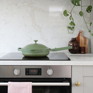 Marble, modern kitchen worktop with electric hob and green Always Pan