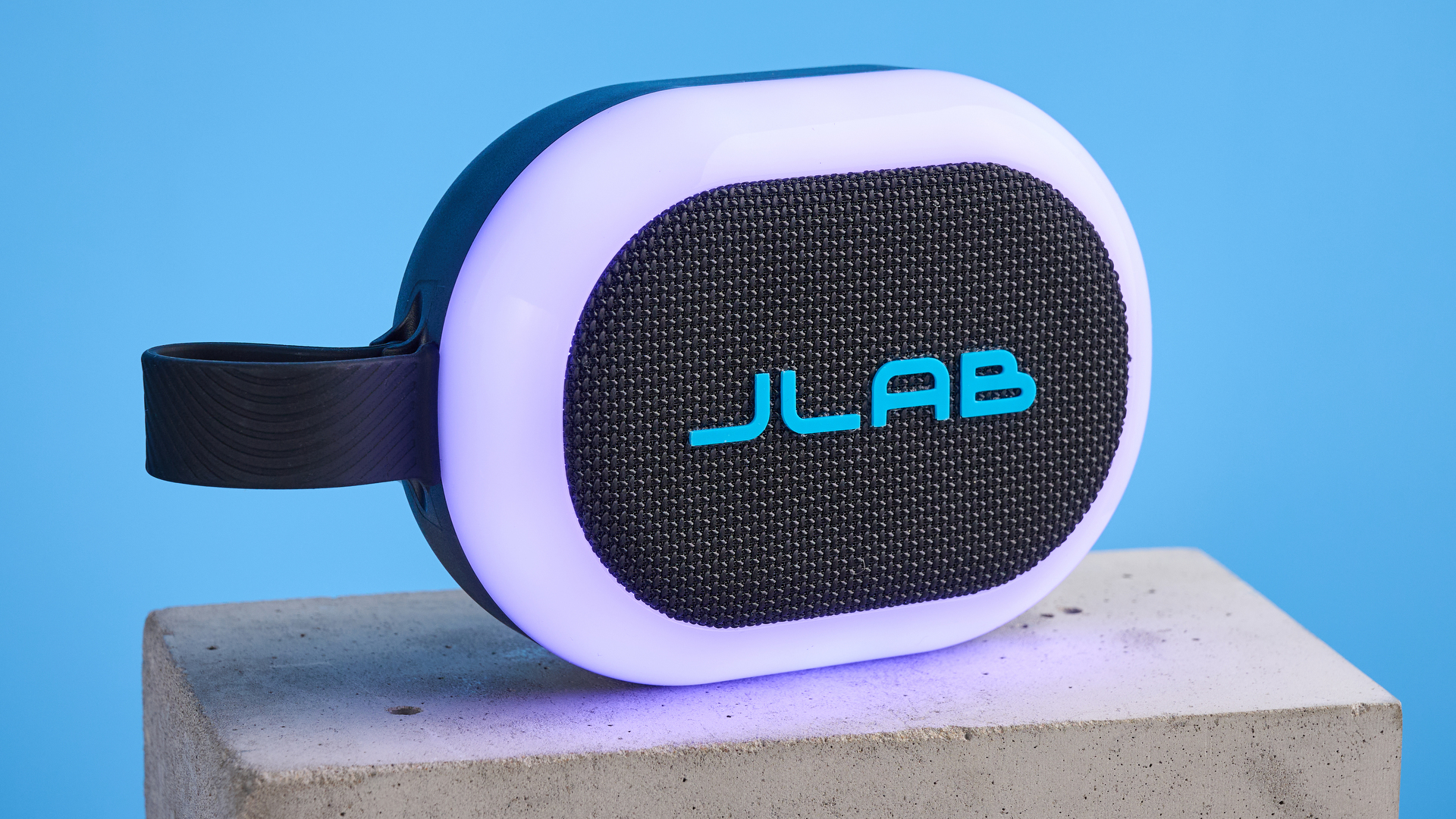 JLab Pop Party portable Bluetooth speaker with RGB lighting photographed on a blue background.