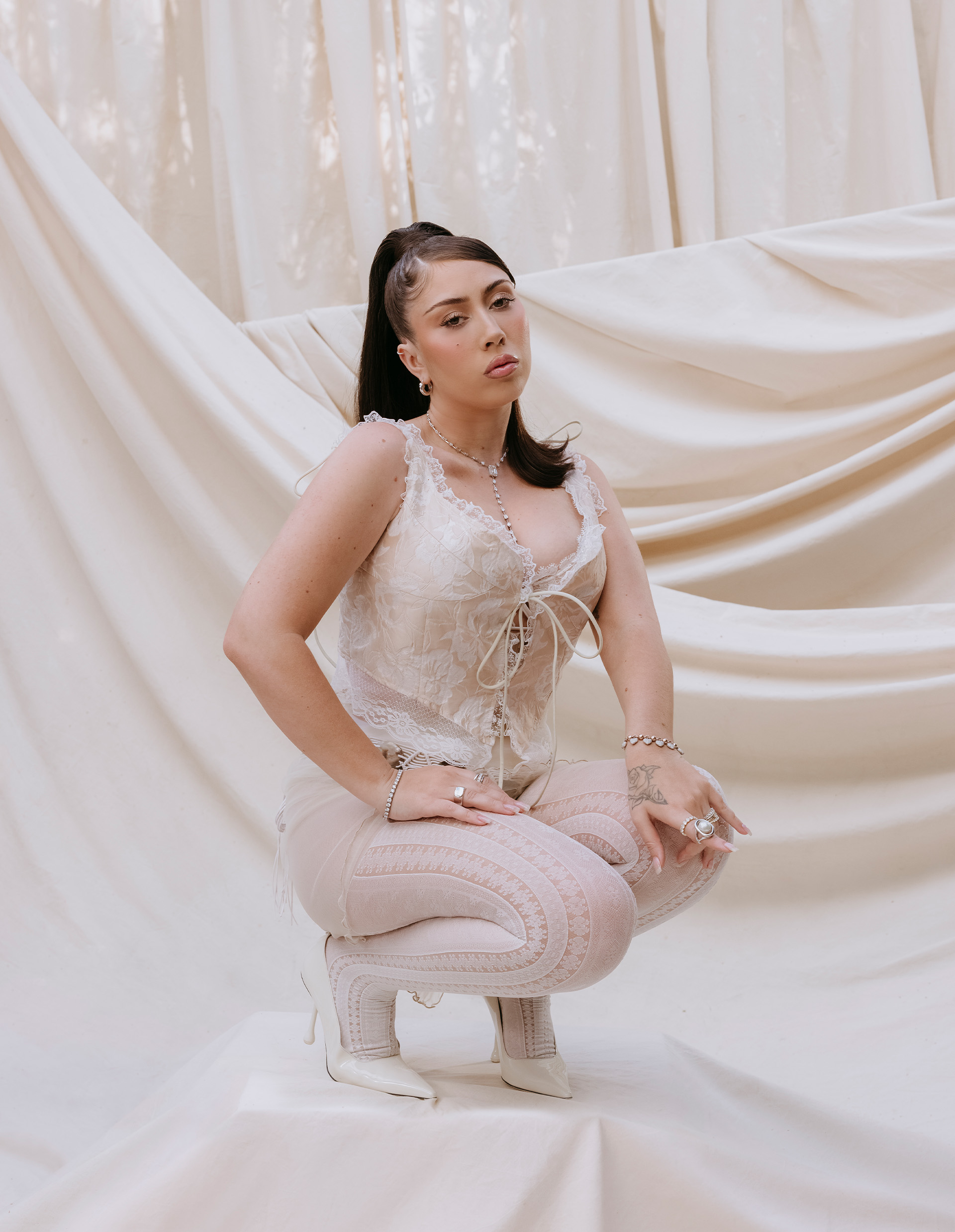 Kali Uchis kneeling wearing a white corset