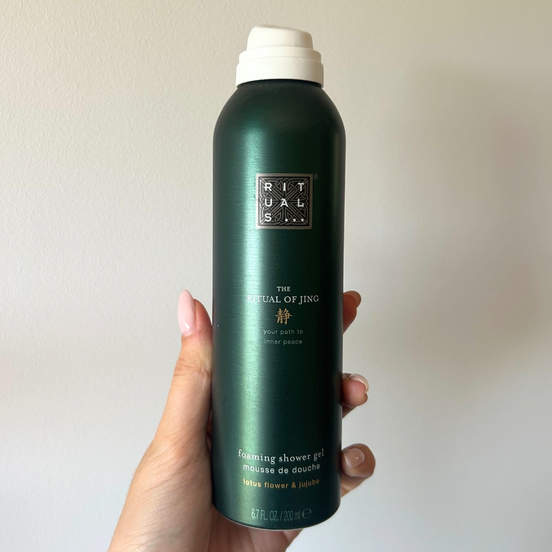 Hand holding empty canister of Rituals The Ritual of Jing Foaming Shower Gel