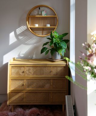 Rattan console with matching wall shelf, styled with a peace lily and candles on the shelf