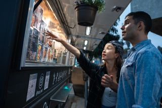 Two people paying at food truck