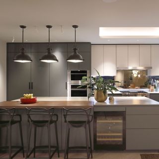 modern grey kitchen with wine cooler and low pendant lighting over island