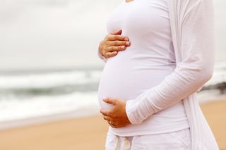 A pregnant woman on the beach.