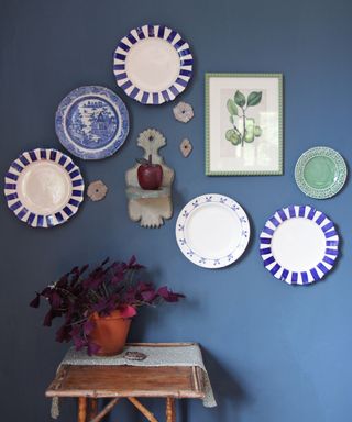 Plates, artwork and collectibles displayed on a blue wall