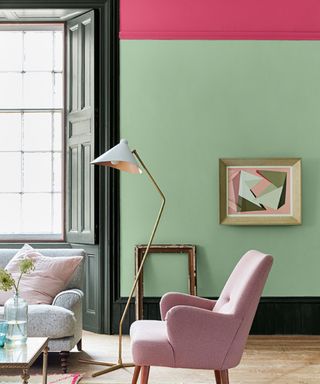 living room with mint green wall, dark pink upper wall and pink armchair