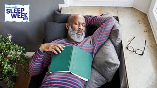 Man napping on a sofa with a book on his chest