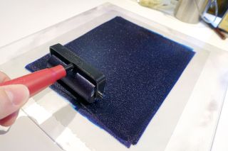 A roller laying down a layer of ink