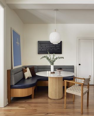 a modern dining room with a dark blue banquette