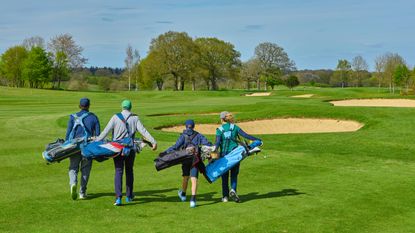 Four golfers walking on fairway