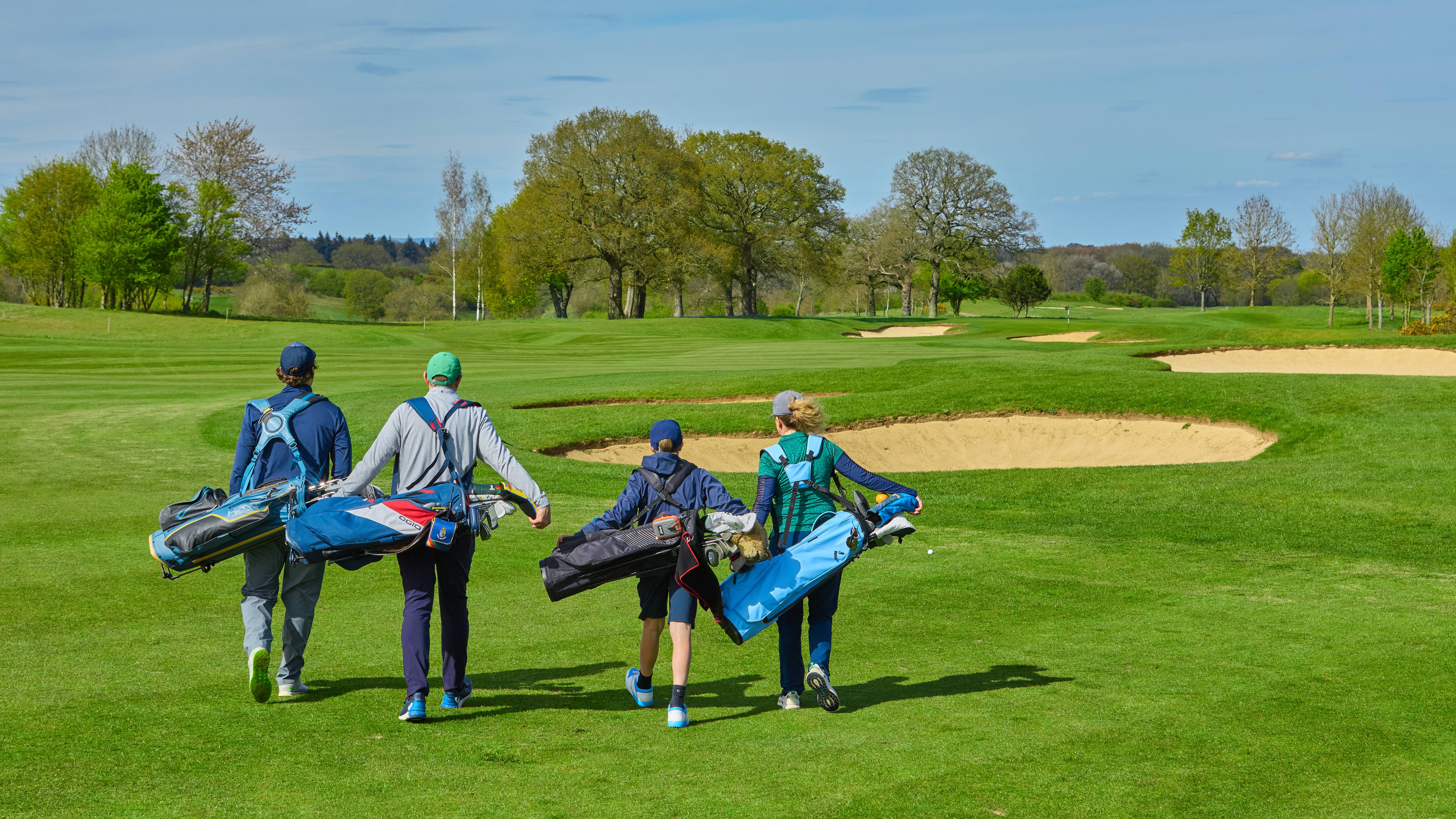 Four golfers walking on fairway