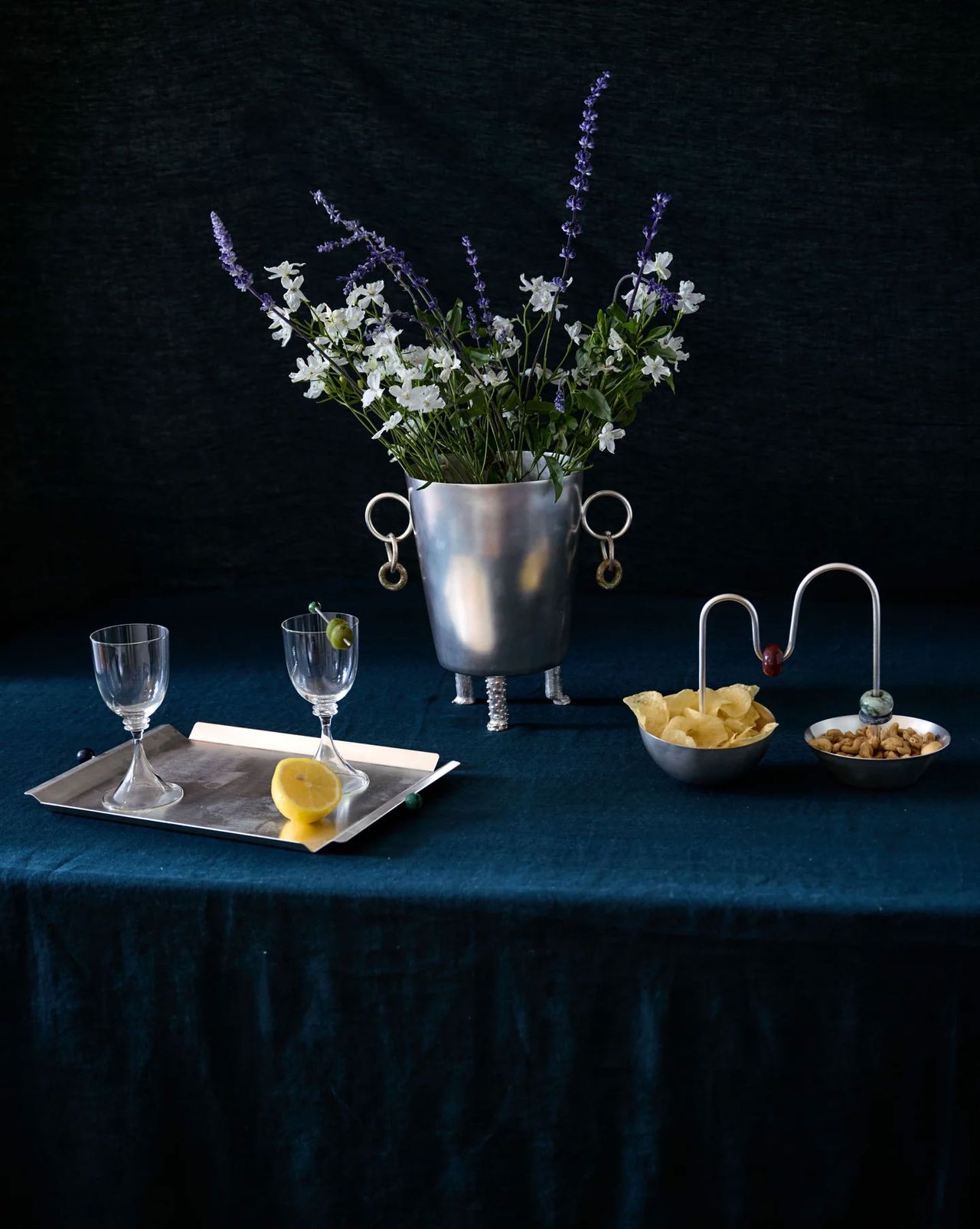 a blue tablecloth with an ice bucket, digestif glasses and serving bowls
