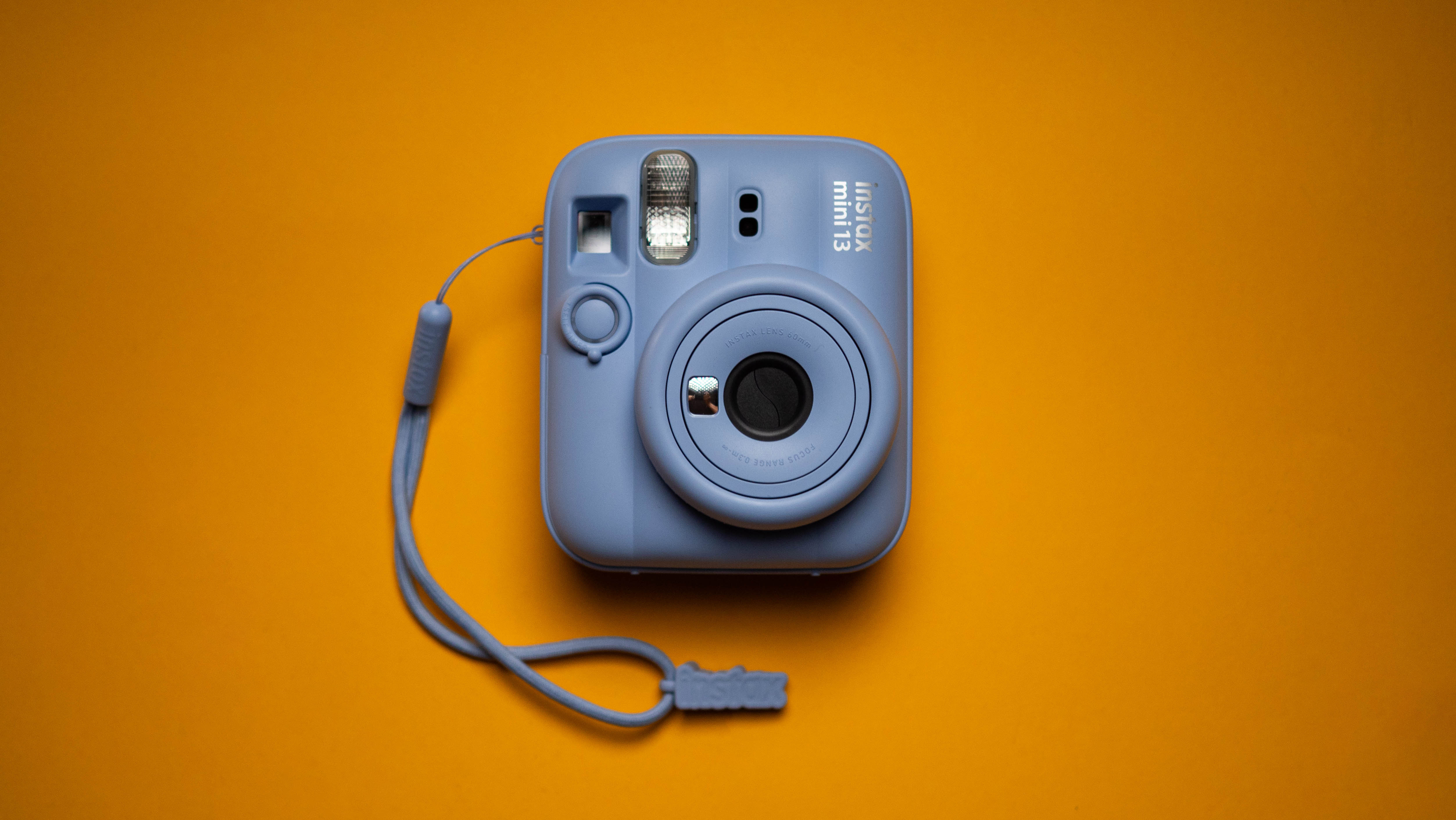 Fujifilm Instax Mini 13 instant camera against a yellow colored sheet