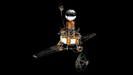 a white and orange-brown space probe with an dish antenna protruding from its bottom, two solar array wings and a spherical section at its top.