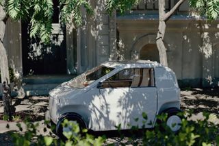 Luvly O light urban vehicle (LUV) parked under a tree and dappled with shade