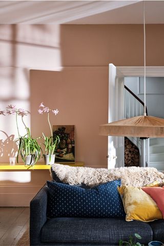 pink living room with large ceiling lampshade and sofa