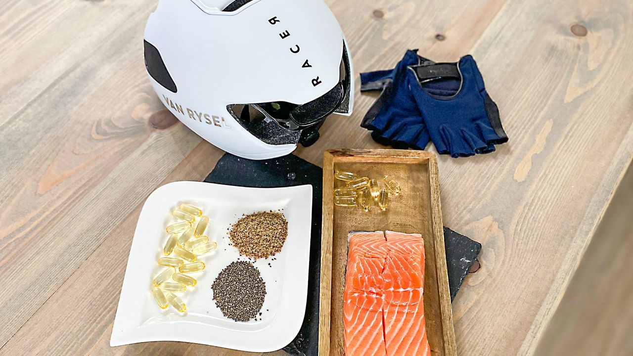 Sources of fish oil placed next to a helmet and cycling mitts