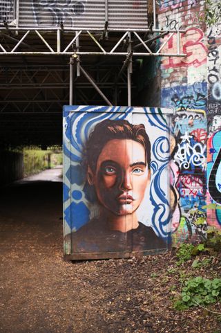 Graffiti of a person's face on a bridge
