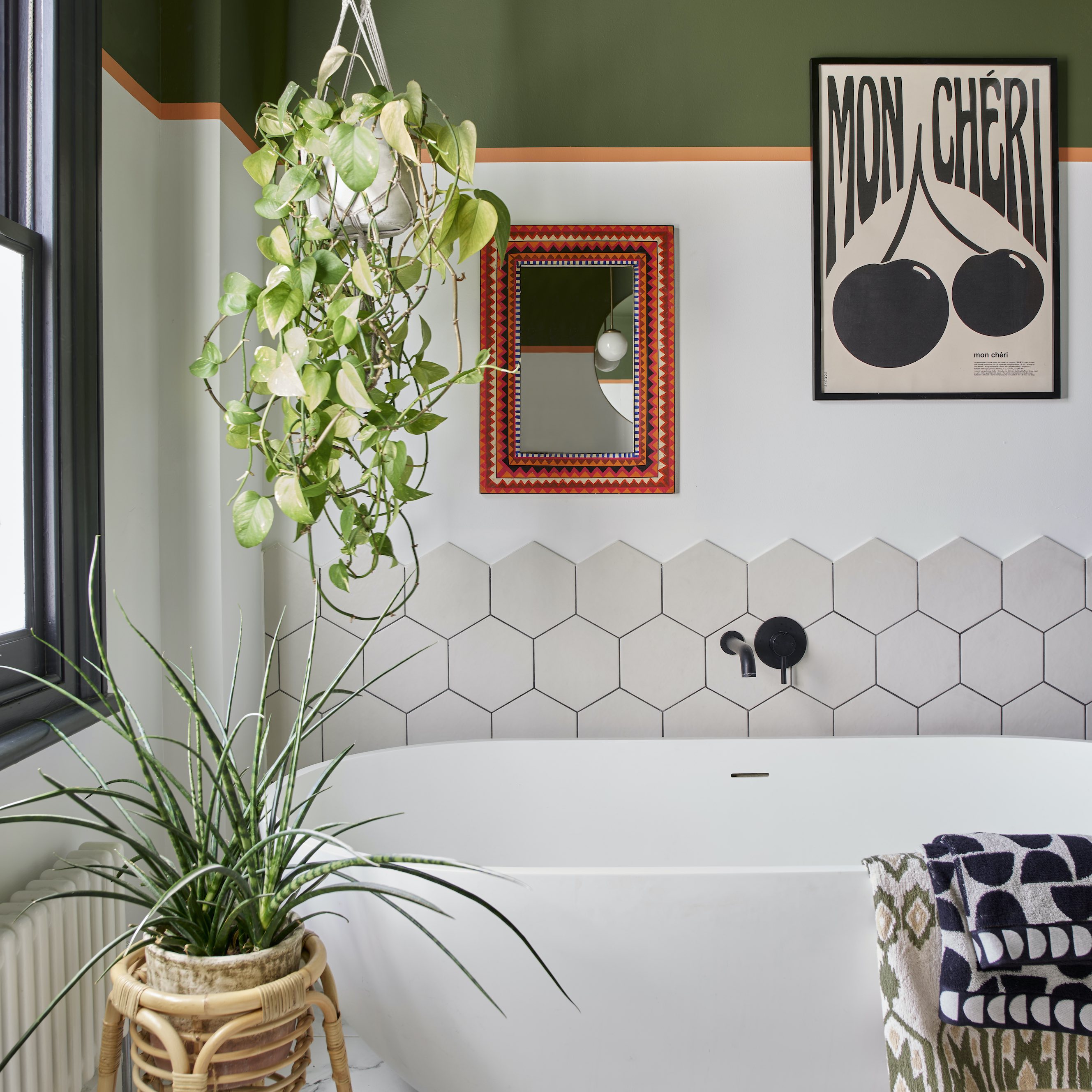 white bath with hex tiles and white, orange and green walls