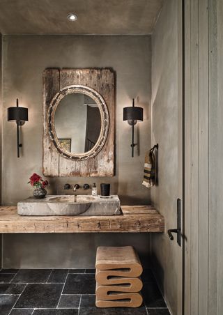 A bathroom with limewash walls, and light fixtures that add warm illumination to the room