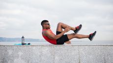 Man doing crunches on a wall