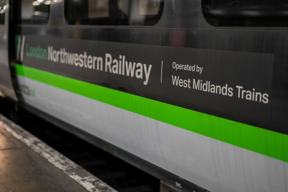 A train operated by the West Midlands Trainline parked in a station 