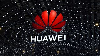 The Huawei logo suspended above the conference floor at MWC 2025, set against a backdrop of many small lights in concentric shapes.