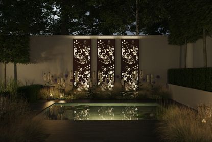 iluminated garden trellises by a outdoor pool 
