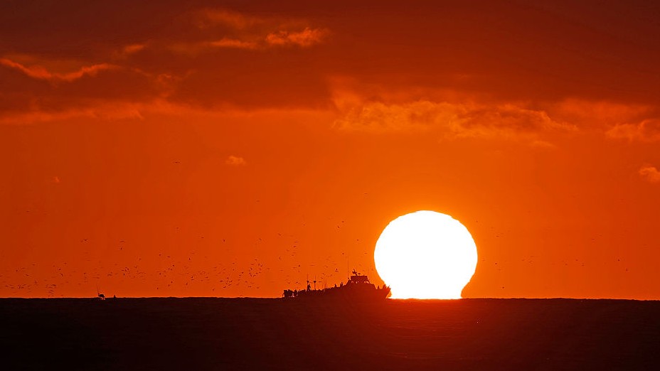 Fishing boat against a hot red sunset