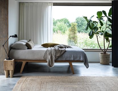 minimalist bedroom with concrete walls and grey bedding