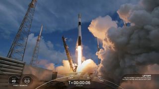 rocket lifting off from launch pad with clouds billowing around